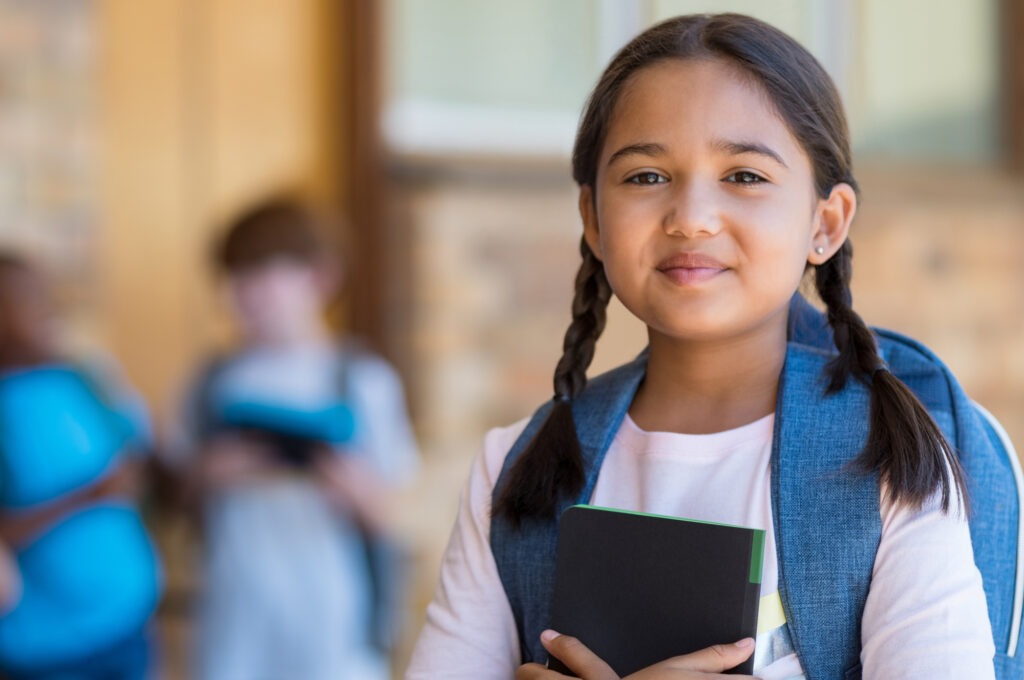 Smiling student girl wearing school backpack